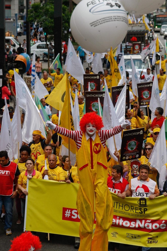 No saguão do Museu de Arte de São Paulo (MASP), cerca de 700 pessoas se reuniram com cartazes, muitas fantasiadas como o palhaço “Ronald McDonald”, e no final incendiaram um caixão simbolizando o enterro do personagem. | Carlos Villalba R./EFE