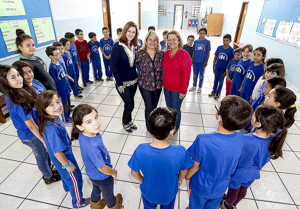 A diretora Maria Cristina (ao centro) e equipe com alunos da Germano Paciornik: reunião com os pais criou pacto de trabalho conjunto. | Henry Milleo / Gazeta do Povo