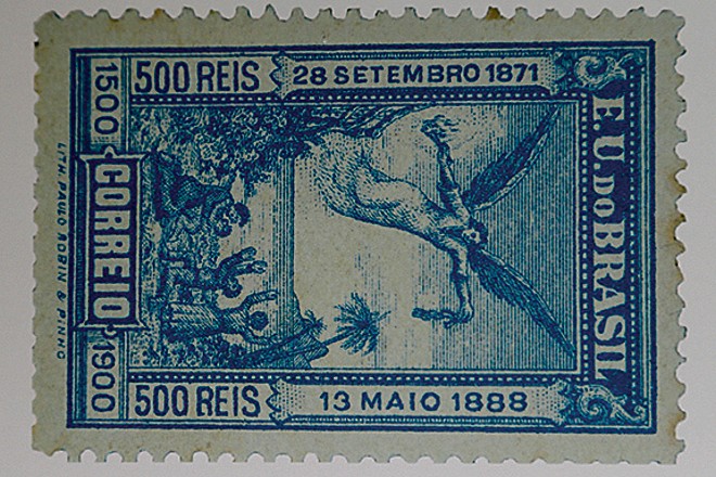 Anjo retira os grilhões de escravos. O selo faz alusão à Lei Áurea, promulgada em 13 de maio de 1888, pela princesa Isabel, que permitia a liberdade a todos os escravos do país. | Albari Rosa/Gazeta do Povo