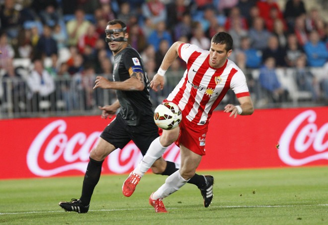 ZORRO: Usando uma máscara protetora, Juanfran (esq.), capitão do Levante, disputa a bola com o atacante Tomer Hemed, do Almería. | Carlos Barba/EFE