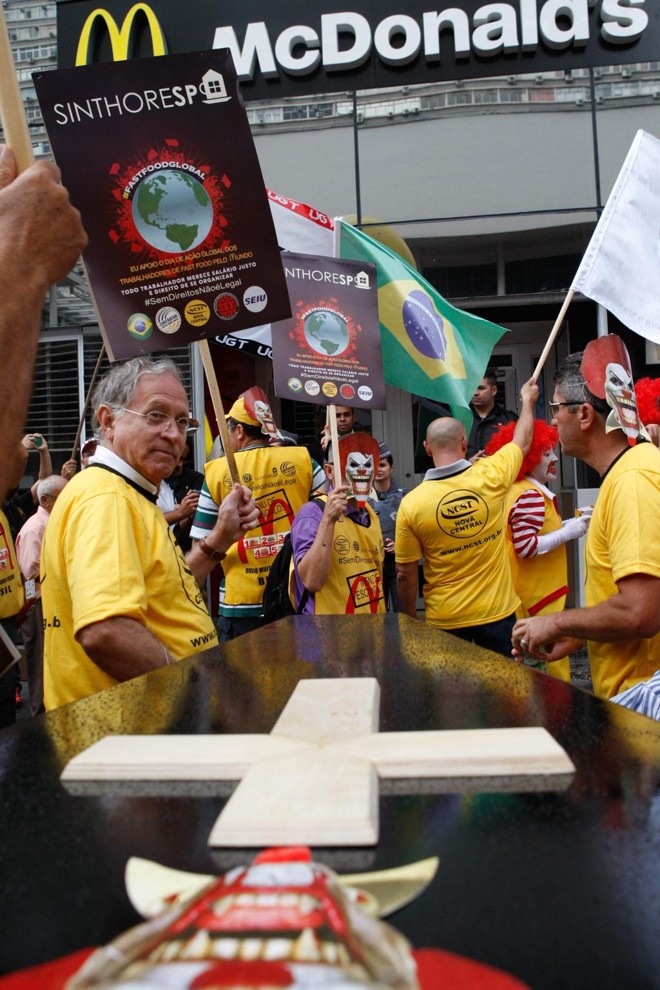 No saguão do Museu de Arte de São Paulo (MASP), cerca de 700 pessoas se reuniram com cartazes, muitas fantasiadas como o palhaço “Ronald McDonald”, e no final incendiaram um caixão simbolizando o enterro do personagem. | Carlos Villalba R./EFE
