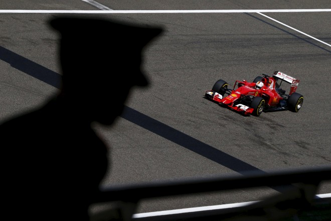Vettel sob a sombra do policial chinês. | CARLOS BARRIA/REUTERS