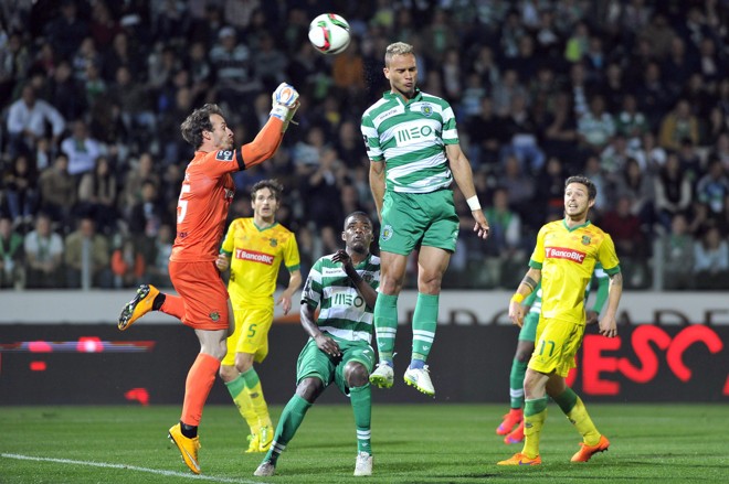 EJETAR: O brasileiro Everton, do Sporting Lisboa, pula para disputar a bola com o goleiro Antonio Filipe, do Paços de Ferreira, pelo Português. | OCTAVIO PASSOS/EFE