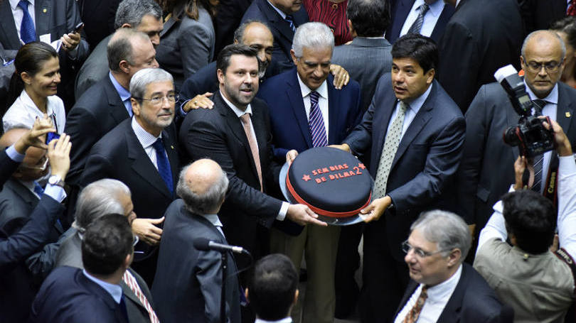 Os parlamentares acenderam velas sobre o bolo preto e vermelho | /Agência Câmara