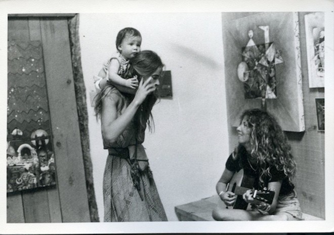 Mulher com criança nas costas. |