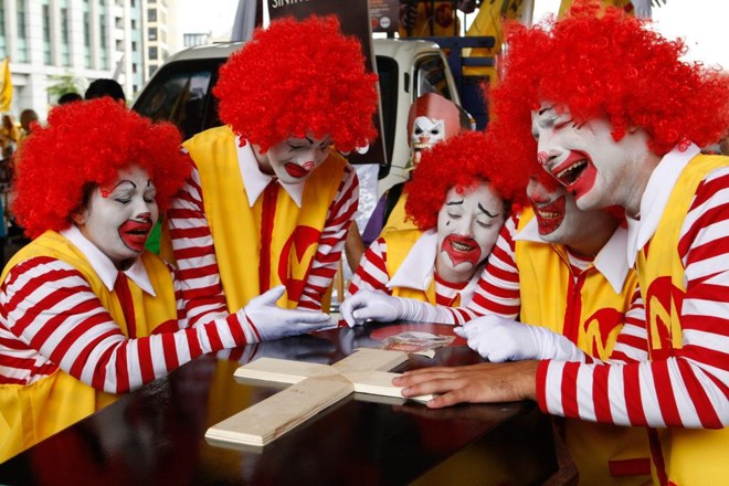 No saguão do Museu de Arte de São Paulo (MASP), cerca de 700 pessoas se reuniram com cartazes, muitas fantasiadas como o palhaço “Ronald McDonald”, e no final incendiaram um caixão simbolizando o enterro do personagem | Carlos Villalba R./EFE