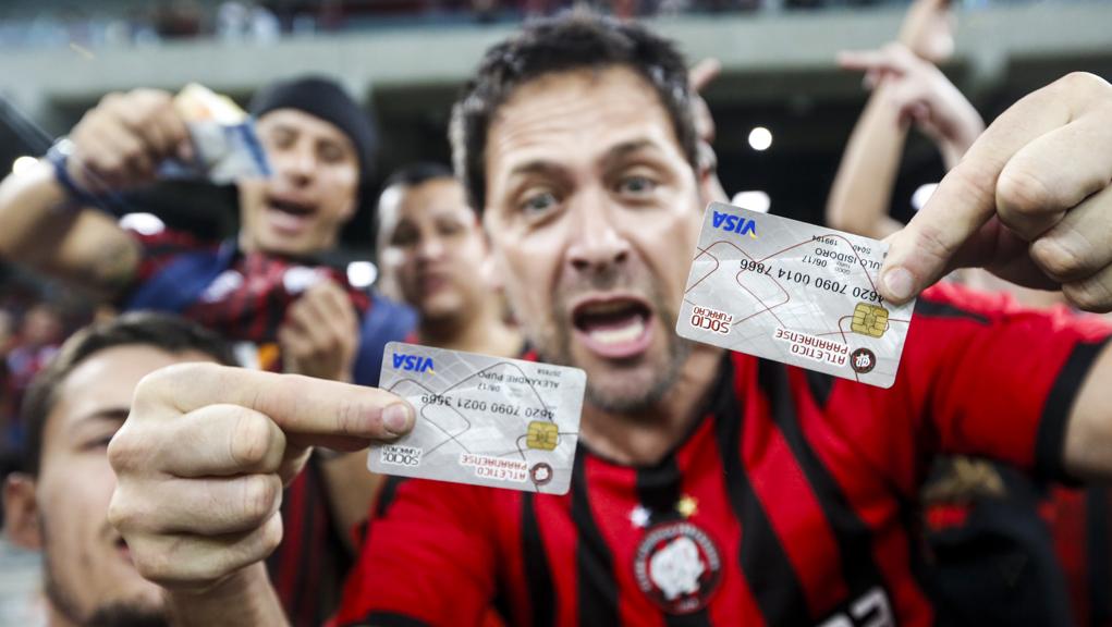 Com um cartão de sócio em cada mão, o torcedor cobra um time à altura da tradição do Atlético – e da salgada mensalidade. | Brunno Covello/Gazeta do Povo