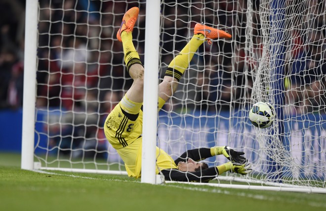 A corrida desabalada, porém, termina com goleiro e bola dentro do gol. | Tony O'Brien/REUTERS