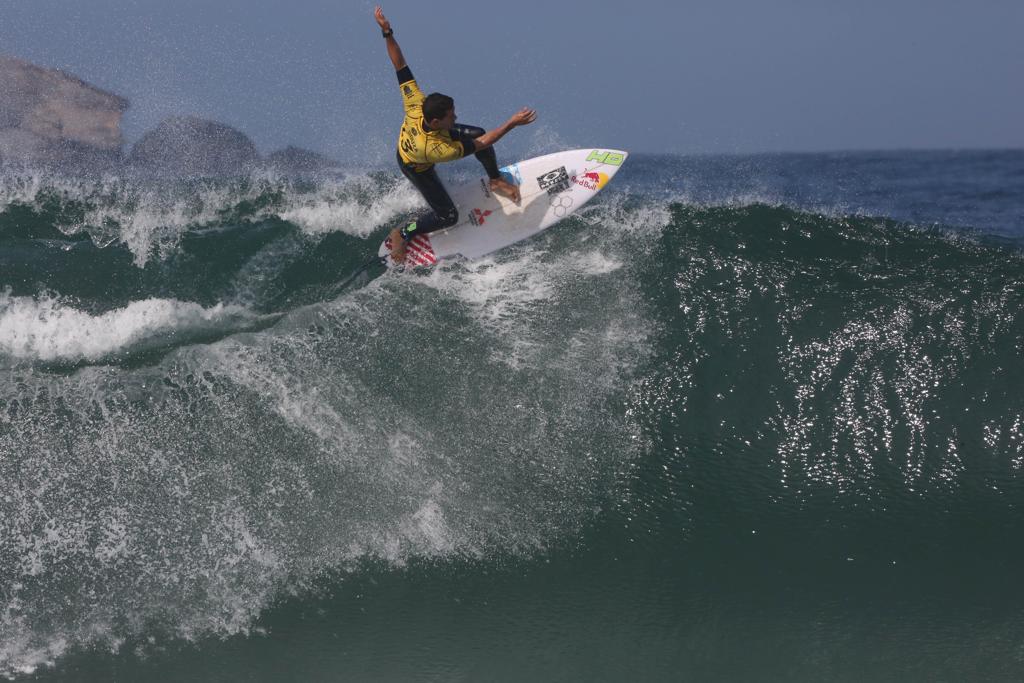 Mineirinho, com a camisa amarela de líder do ranking, faz manobra no primeiro round da etapa do Rio do Mundial de surfe. | Daniel Castelo Branco/Estadão Conteúdo