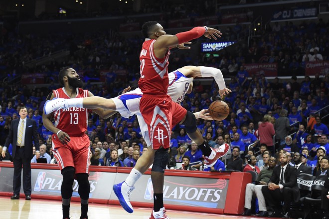 PONTE – Como um bom goleiro, Blake Griffin faz uma “ponte” para ficar com a bola em lance contra o grandalhão Dwight Howard. | Richard Mackson/USA Today Sports