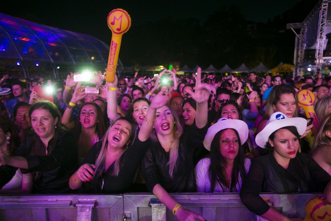 As amigas Suellen Colaço e Giovana Sabin (no centro) estavam com todas as músicas na ponta da língua. | Brunno Covello/Gazeta do Povo