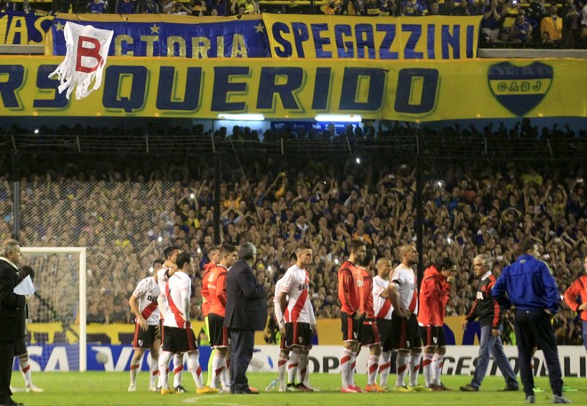 Jogadores tiveram de esperar por mais de uma hora no gramado até o jogo ser suspenso. Na parte de cima da foto o drone que “passeou” pelo estádio relembrando o rebaixamento do River. | ENRIQUE MARCARIAN/REUTERS
