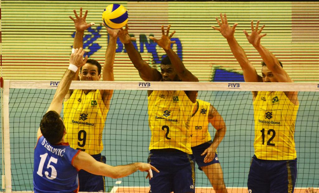 Bloqueio brasileiro sobe para segurar o ataque sérvio na primeira partida da seleção na Liga Mundial deste ano. | FIVB/Divulgação
