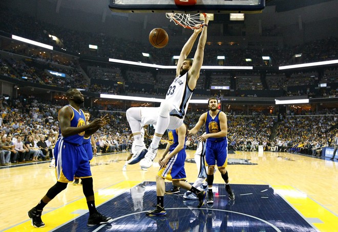 PENDURADO – Marc Gasol, do Memphis Grizzlies, se agarrou como pôde na cesta depois de fazer a enterrada contra o Golden State Warriors. Jogo duro para os donos da casa. | Mike Brown/EFE