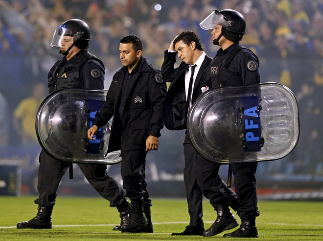 O técnico do River, Marcelo Gallardo, protegido por policiais. | ENRIQUE MARCARIAN/REUTERS