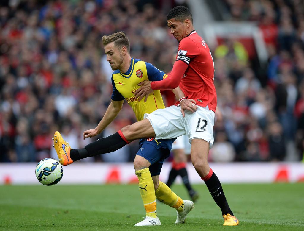 Chris Smalling (à dir), do Manchester United, disputa bola com Aaron Ramsey, doArsenal | Nigel Roddis/EFE