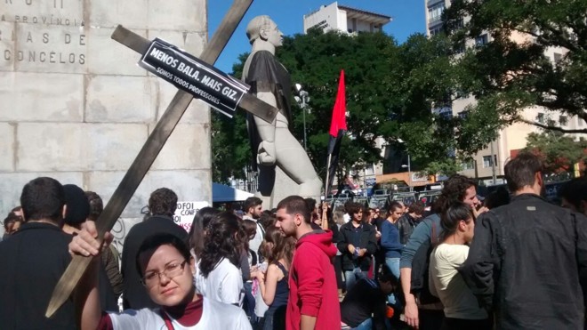 Manifestante mostra cruz com a frase “Menos bala, mais giz”. | Antônio More Gazeta do Povo