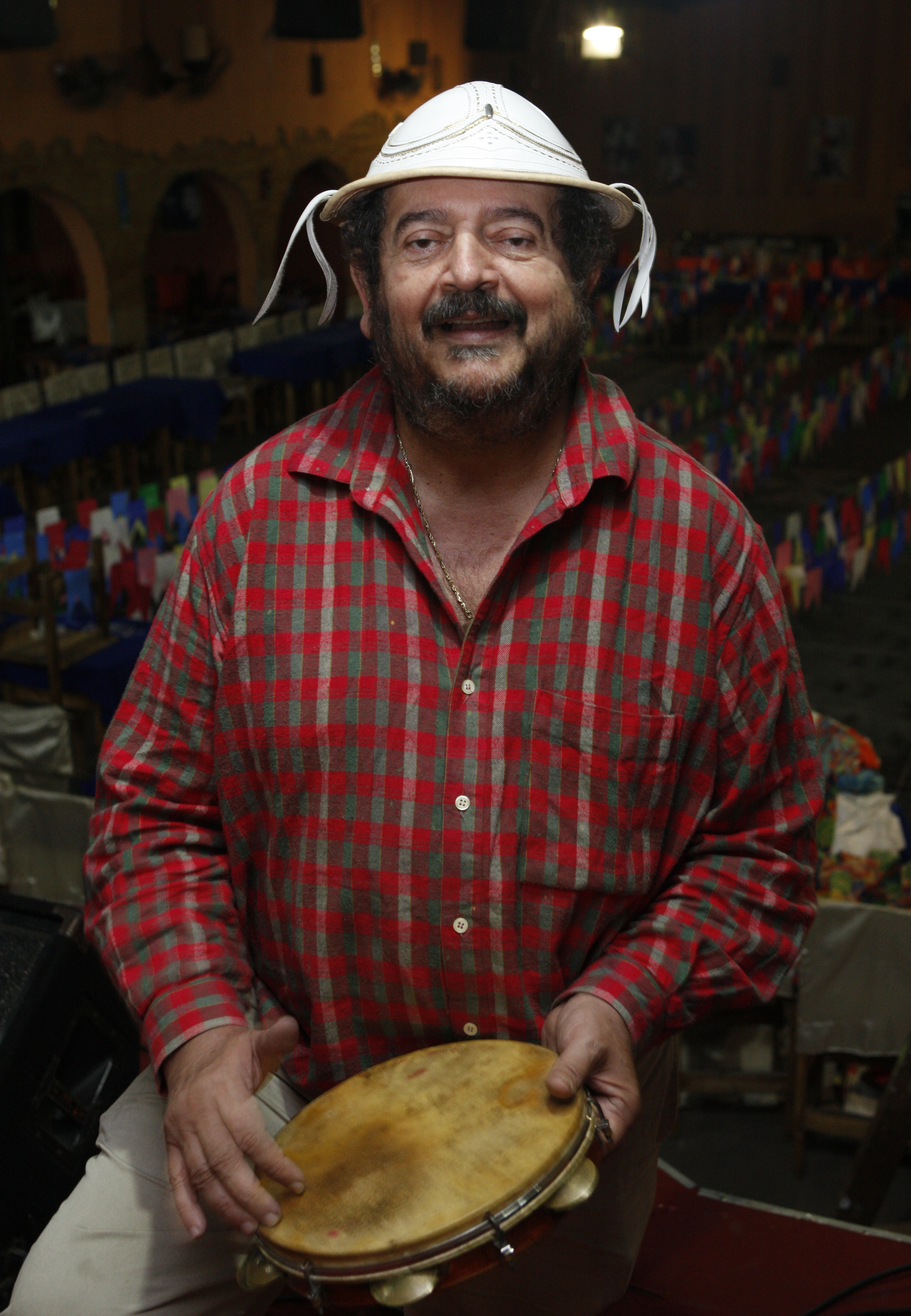 Maérlio Barbosa, o Ceará, batucando o pandeiro enquanto prepara festa para o sábado (20). | Aniele Nascimento/Gazeta do Povo