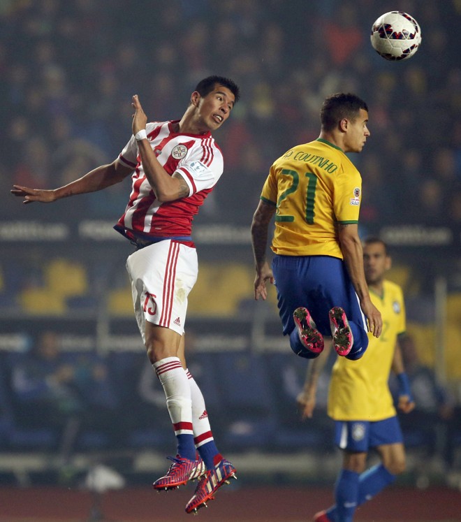 Philippe Coutinho pula com Victor Caceres em disputa pela bola. | ANDRES STAPFF/REUTERS