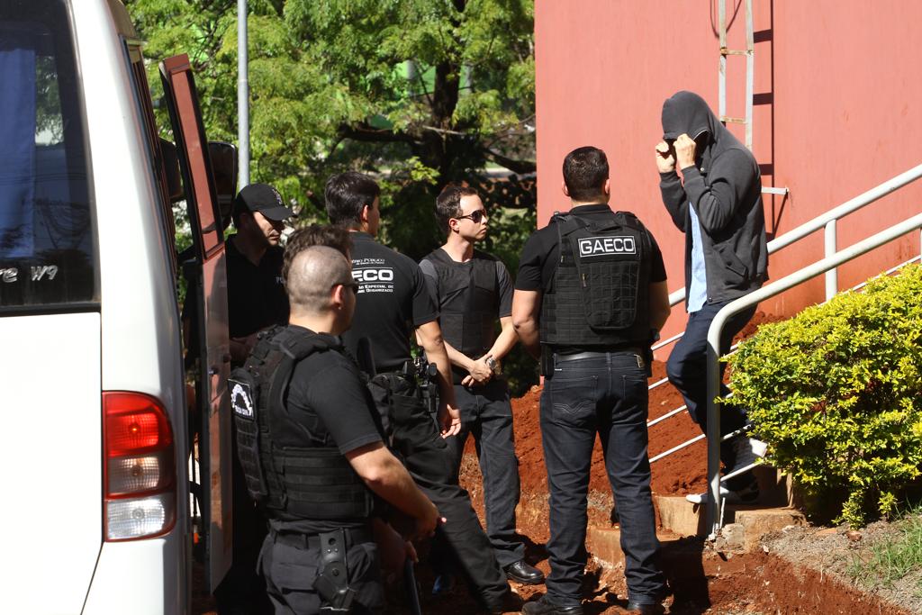 Agentes do Gaeco observam um dos presos, que esconde o rosto. | Roberto Custódio/Jornal de Londrina