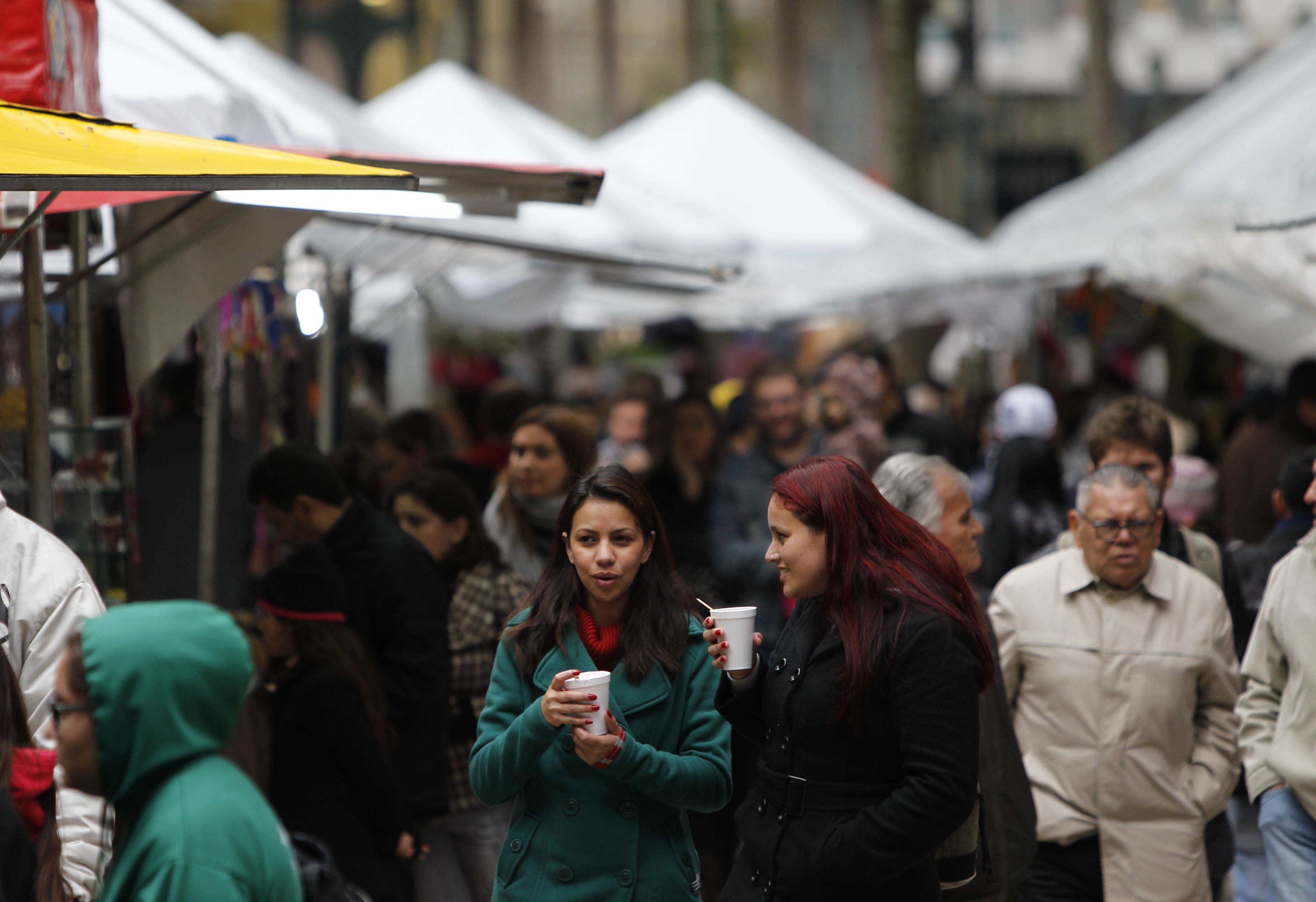 As amigas Loriane da Silva e Erica de Souza aproveitaram a feirinha da Praça Osório para tomar um quentão. | Jonathan Campos/Gazeta do Povo