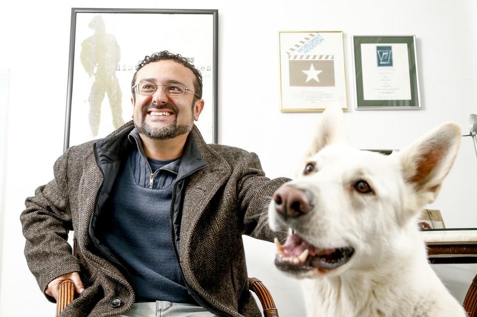 Cineasta no escritório, na companhia do cachorro Gigante: “As melhores ideias estão na tevê; o cinema ficou mais infantil.” | Hugo Harada/Gazeta do Povo
