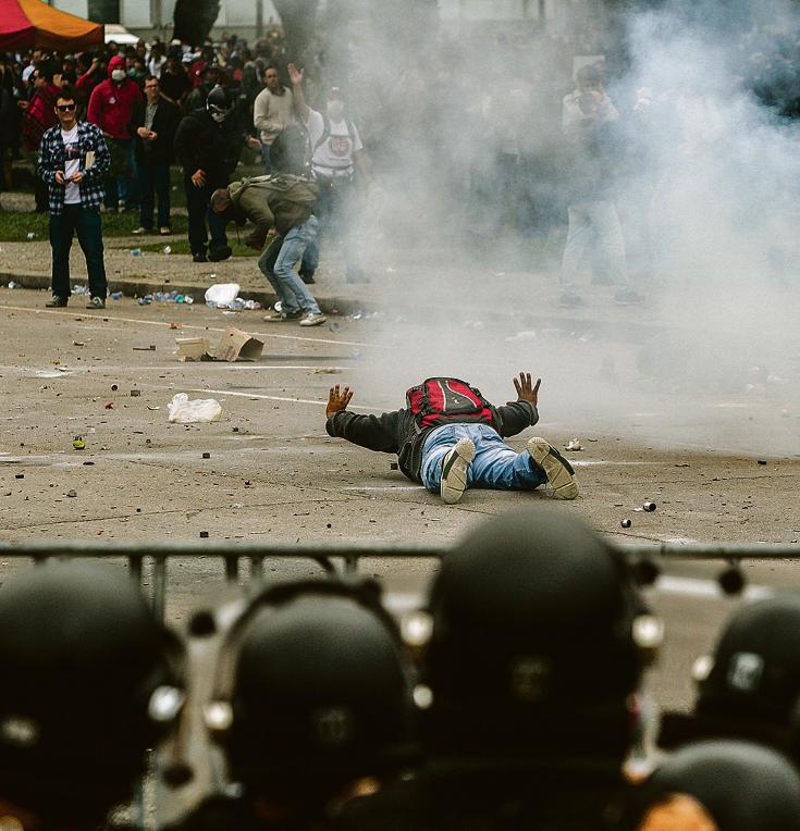 Praça de guerra: manifestante se joga no chão para não ser atingido pelas balas de borracha usadas por policiais na operação. | Daniel Castellano/Gazeta do Povo