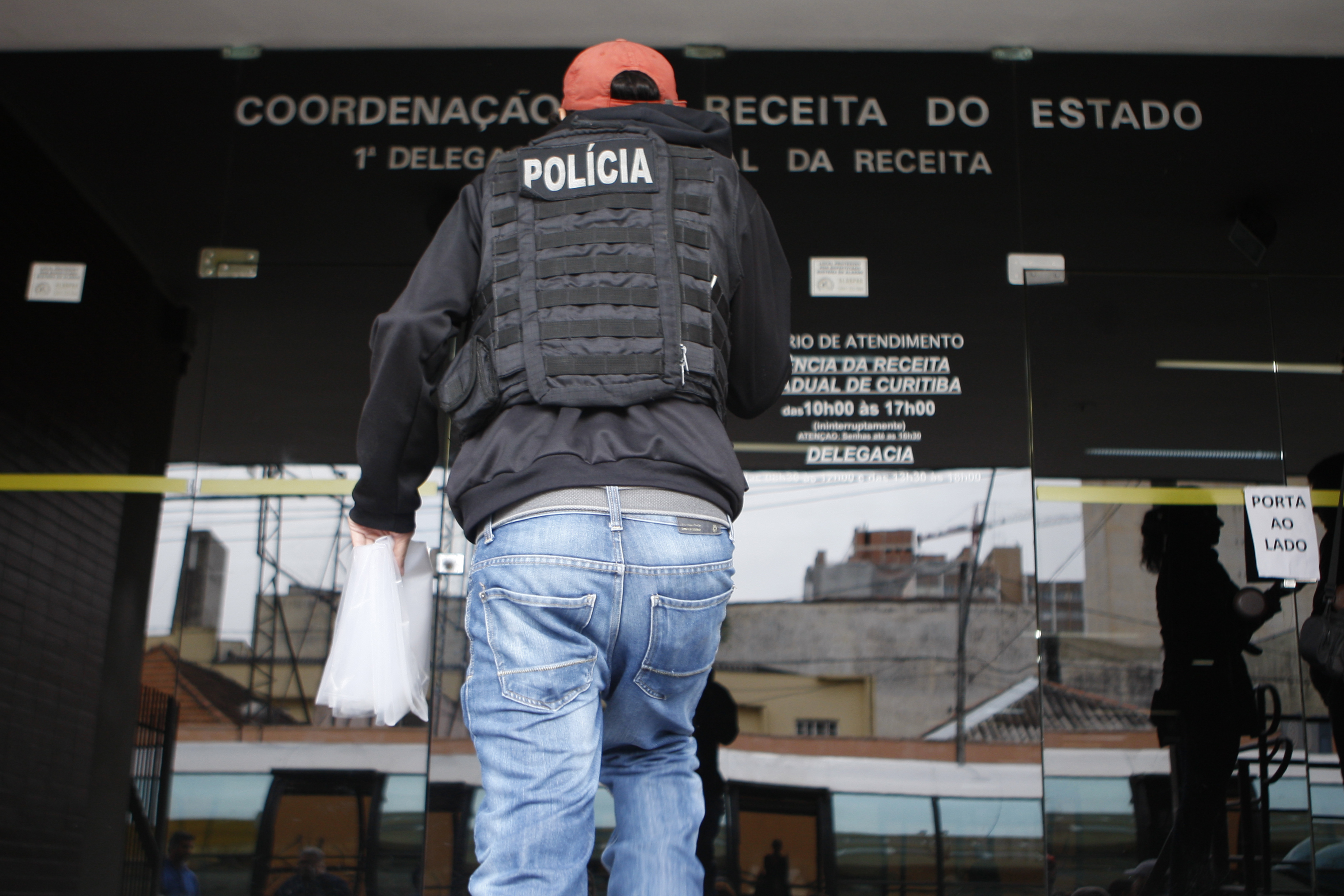 Policial cumpre mandado judicial na principal sede da Receita Estadual em Curitiba, em maio: denúncia acatada pela Justiça é a primeira fora do eixo londrinense do esquema de propina no Fisco do Paraná. | Aniele Nascimento/Gazeta do Povo