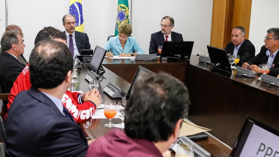Para evitar demissões, governo bancará parte de salário do trabalhador Dilma Rousseff assina MP do Plano de Proteção ao Emprego cercada por ministros e sindicalistas. | Lula Marques/Agência PT/Fotos Públicas