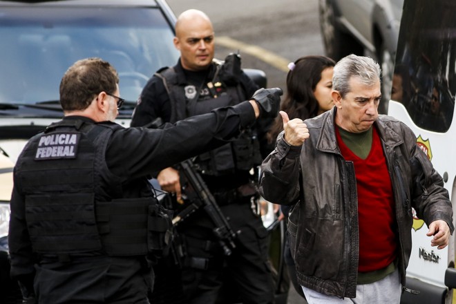 O ex-diretor da Odebrecht, Márcio Faria da Silva, faz sinal de positivo a agente da PF, que lhe indicou o caminho da van | Brunno Covello/Gazeta do Povo