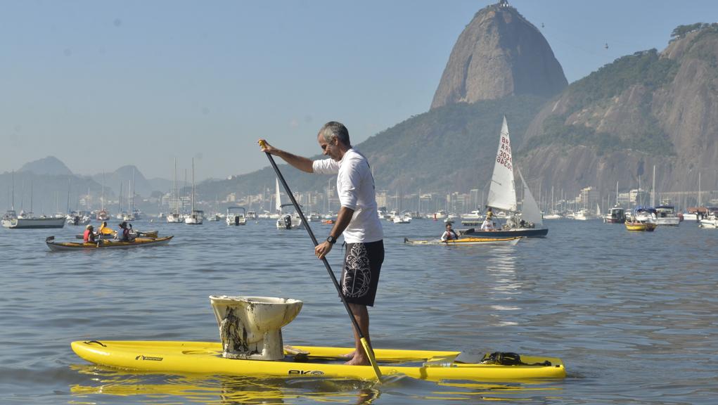 Ambientalista navega pela Baía da Guanabara com vaso sanitário disfarçado de canoa: protestos constantes ainda não surtiram efeito prático. | Fernando Frazão/Agência Brasil