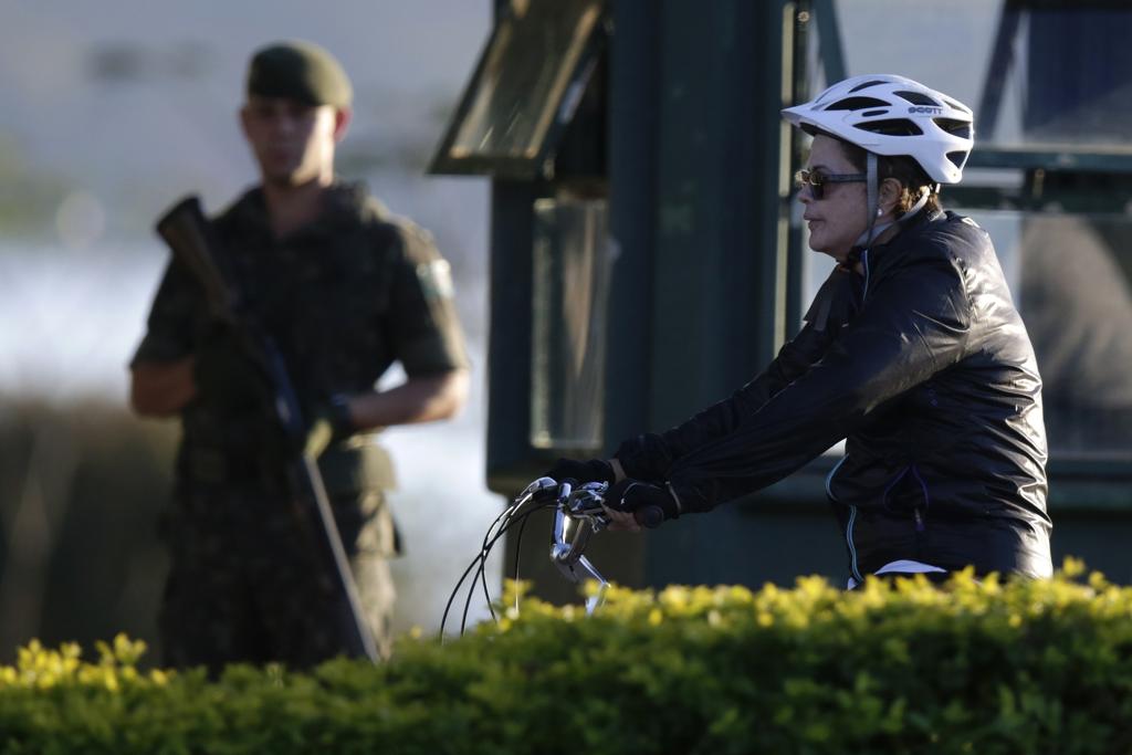 Dilma passeia em Brasília de bicicleta nesta segunda-feira, observada por soldado: na quinta-feira, ela se encontra com governadores para pedir apoio. | Ueslei Marcelino/Reuters