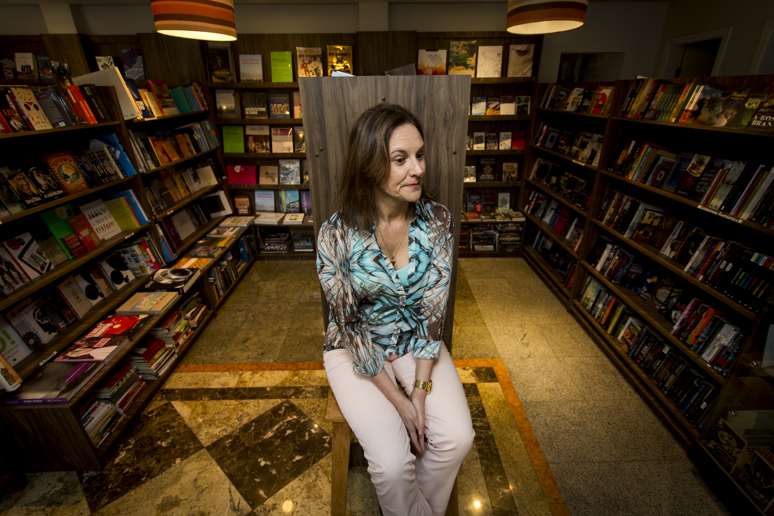 Luci Collin cercada de livros: a escritora garante que, ao longo de sua carreira, não mudou, mas a leitura sim. | Henry Milleo / Gazeta do Povo