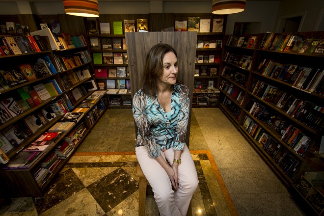 Luci Collin cercada de livros: a escritora garante que, ao longo de sua carreira, não mudou, mas a leitura sim. | Henry Milleo / Gazeta do Povo