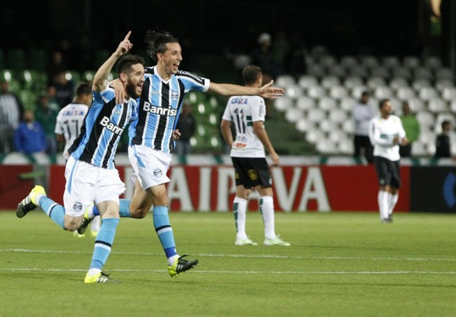 Marcelo Oliveira e Pedro Geromel comemoram o gol da vitória do Grêmio sobre o Coritiba, no Couto Pereira. | Daniel Castellano/Gazeta do Povo