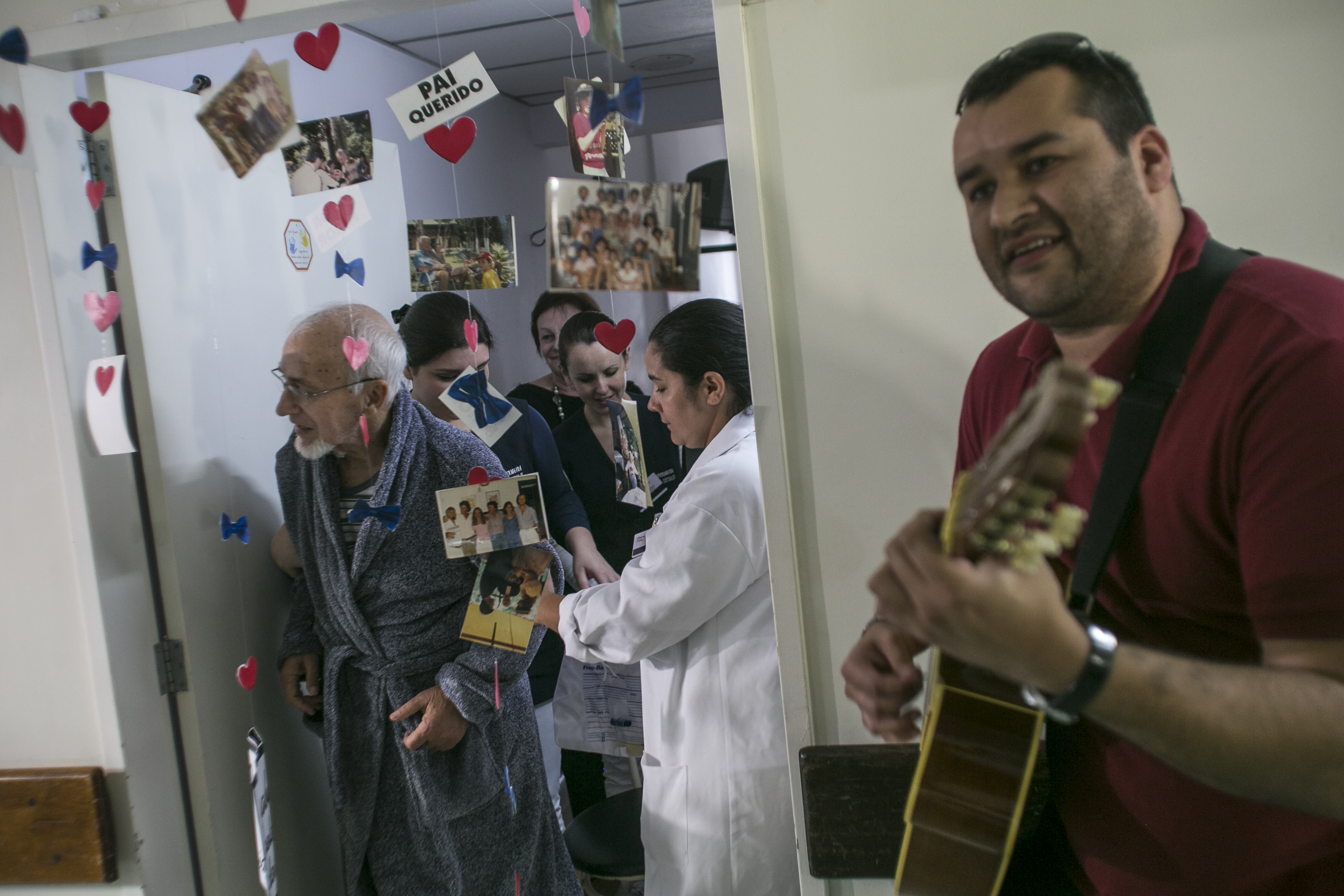 Frank Otto Graf, um dos pacientes internados (à esquerda, de roupão), se emociona ao receber a homenagem | Marcelo Andrade/Gazeta do Povo