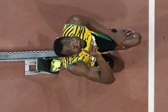Usain Bolt se prepara para a largada dos 200 metros rasos pedindo proteção do alto. | KIM KYUNG-HOON/REUTERS