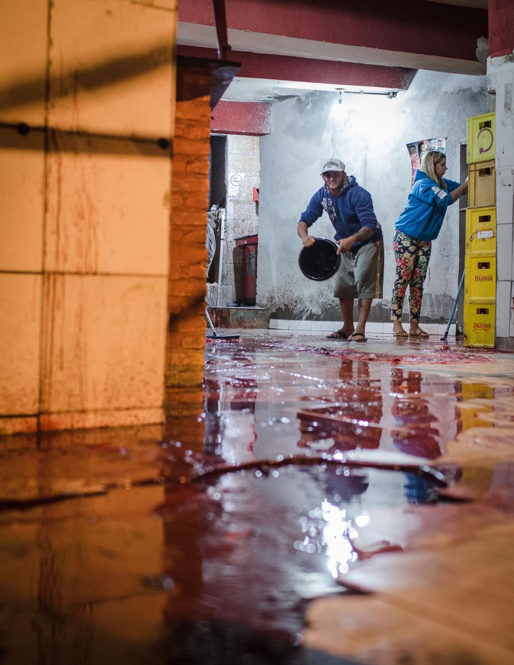 Funcionários limpam um bar em Osasco que foi alvo dos atiradores que mataram 18 na Grande São Paulo | Avener Prado/Folhapress