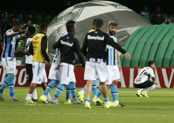 Ao fundo, o jovem atacante Evandro tenta digerir o resultado negativo do Coritiba dentro de casa: com o 1 a 0 para o adversário, o Alviverde terá de vencer em Porto Alegre para seguir na competição. | Daniel Castellano/Gazeta do Povo