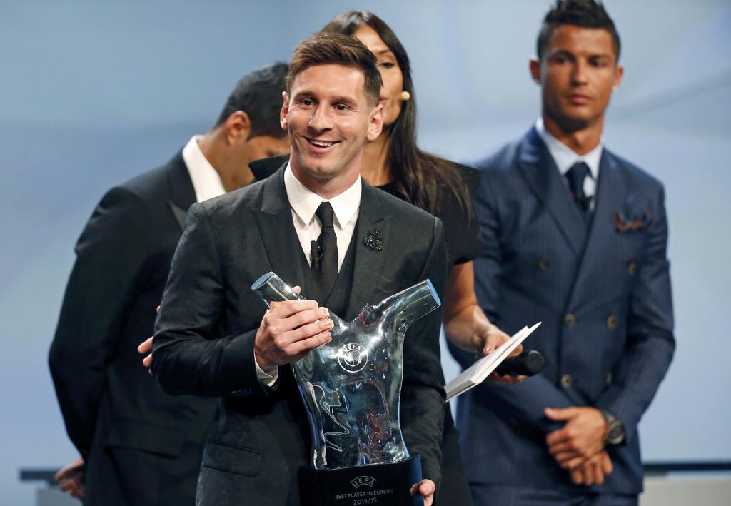 O argentino Lionel Messi segura o troféu de melhor jogador da Europa, superando Cristiano Ronaldo, que aparece logo atrás do meia. | Eric Gaillard/Reuters