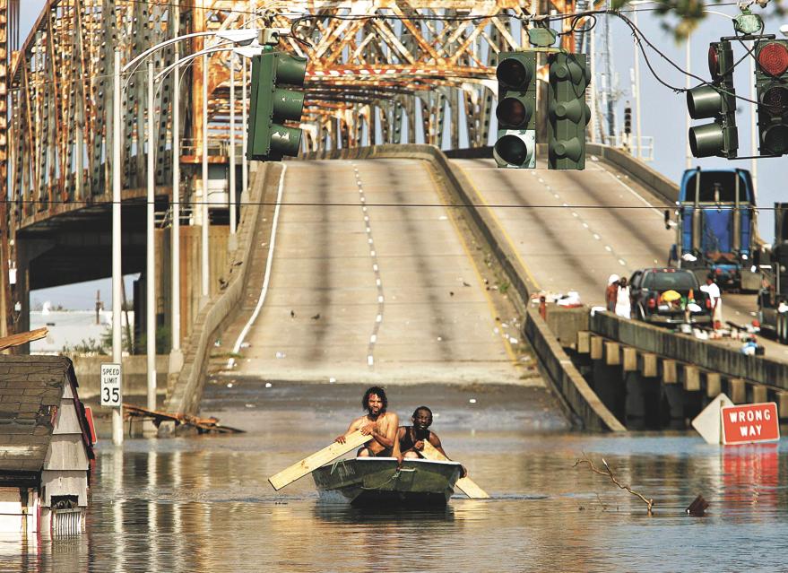 Dois homens remam pela ponte que passa pelo canal, após a tragédia. | Mario Tama/Reuters