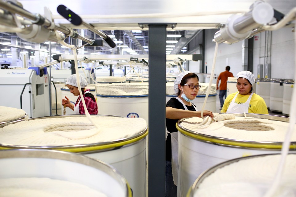 A técnica chinesa Ni Meijuan (centro) num cotonifício do Grupo Keer na Carolina do Sul; produção têxtil na China está deixando de ser lucrativa | Travis Dove/The New York Times