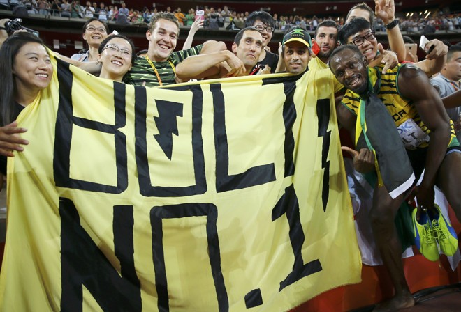 Depois do trabalho bem feito na pista, uma pausa para tirar uma foto com os fãs: “Bolt, o número 1”. | DAMIR SAGOLJ/REUTERS
