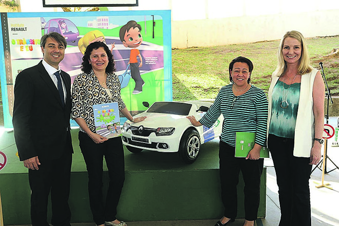 O diretor de Comunicação da Renault e vice-presidente do Instituto Renault, Caíque Ferreira, e a vice-prefeita de Curitiba, Mirian Gonçalves (de colete branco), com Elisiane Falkowski, diretora da Escola Araucária (com a cartilha na mão), e a secretária de Trânsito, Luiza Simonelli (de listrado), no lançamento do programa “O Trânsito e Eu”. Foto: Guilherme Costa/La Imagem. | 