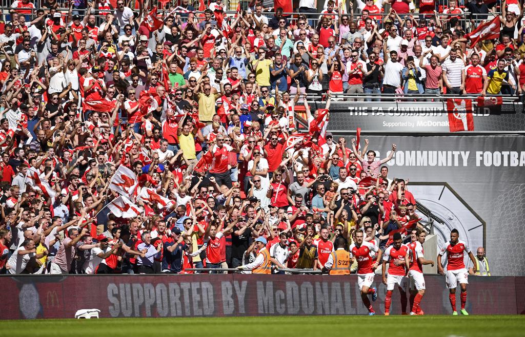Jogadores do Arsenal comemora gol de Oxlade-Chamberlain ao lado da torcida em Wembley. | Dylan Martinez/REUTERS