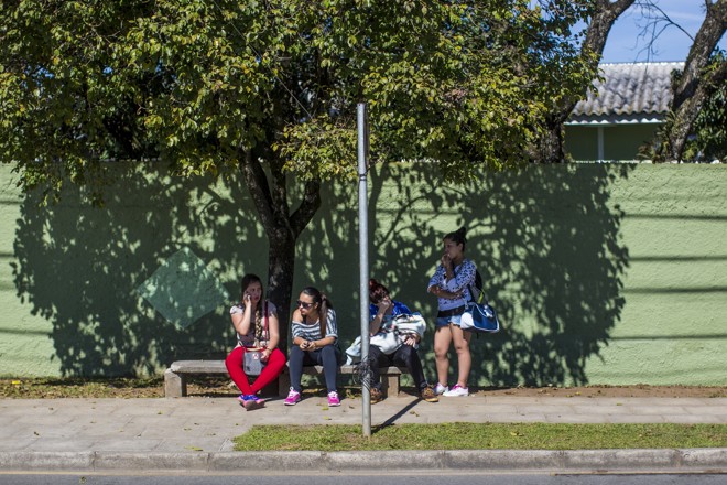 População aguarda ônibus na sombra, em dia quente. | Brunno Covello/Gazeta do Povo