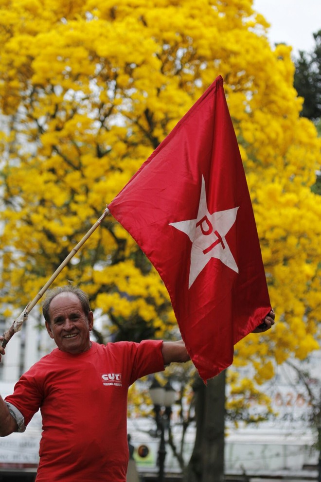 Os participantes do ato vestem roupas na cor vermelha e carregam bandeiras de movimentos pró-Dilma | Jonathan Campos/Gazeta do Povo