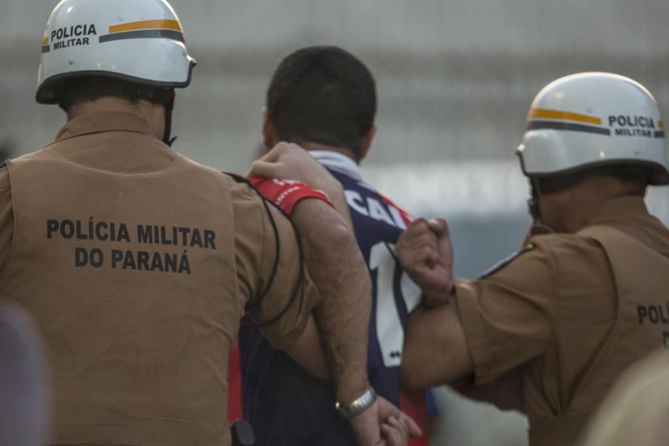 Policiais retiram torcedor do Paraná após briga na Vila Capanema, em jogo contra o CRB, pela Série B. | Marcelo Andrade/Gazeta do Povo