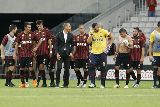 Jogadores do Atlético e o técnico Milton Mendes deixam o gramado da Arena sob protestos da torcida. | Daniel Castellano / Gazeta do Povo