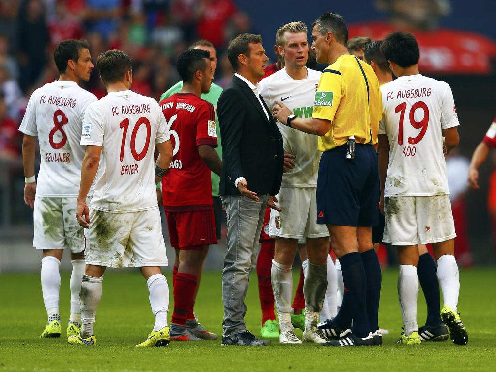 Técnico do Augsburg Markus Weinzierl reclama com árbitro Knut Kircher sobre o pênalti marcado no fim da partida | MICHAEL DALDER/REUTERS
